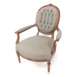 A Victorian mahogany balloon back armchair, with foliate carving, green patterned fabric, button bac