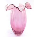 A Victorian cranberry glass ribbed vase, with a wavy frilled neck, 27cm high.