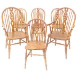 A set of six 19thC oak and elm wheelback dining chairs, with solid saddle seats, raised on turned le