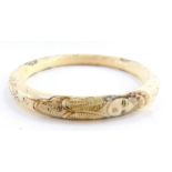 A Japanese late Taisho / early Showa period marine ivory bangle, carved in bas relief with three fi