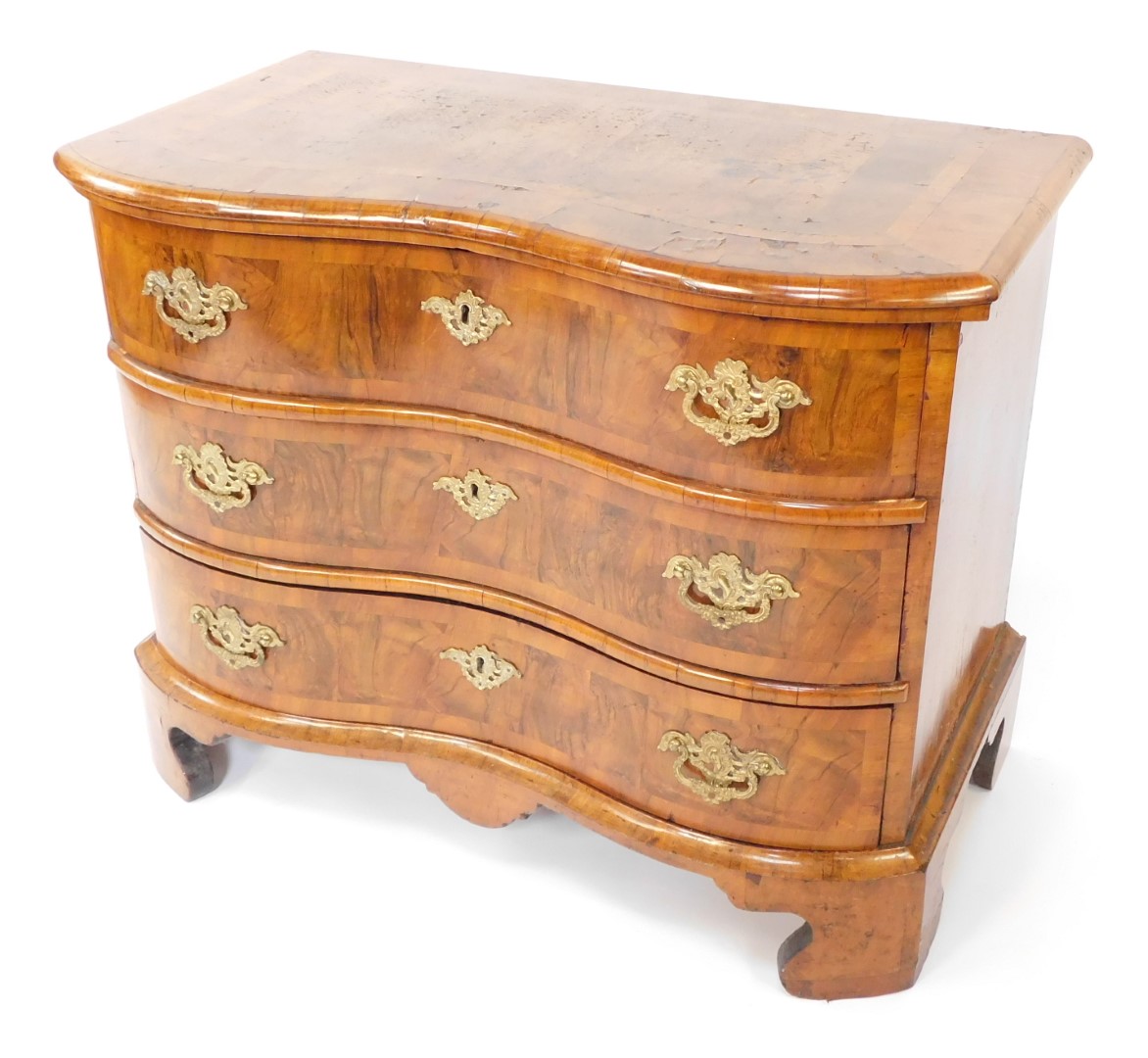 An early 19thC Dutch walnut serpentine chest, with deep cross banded and moulded top over three draw