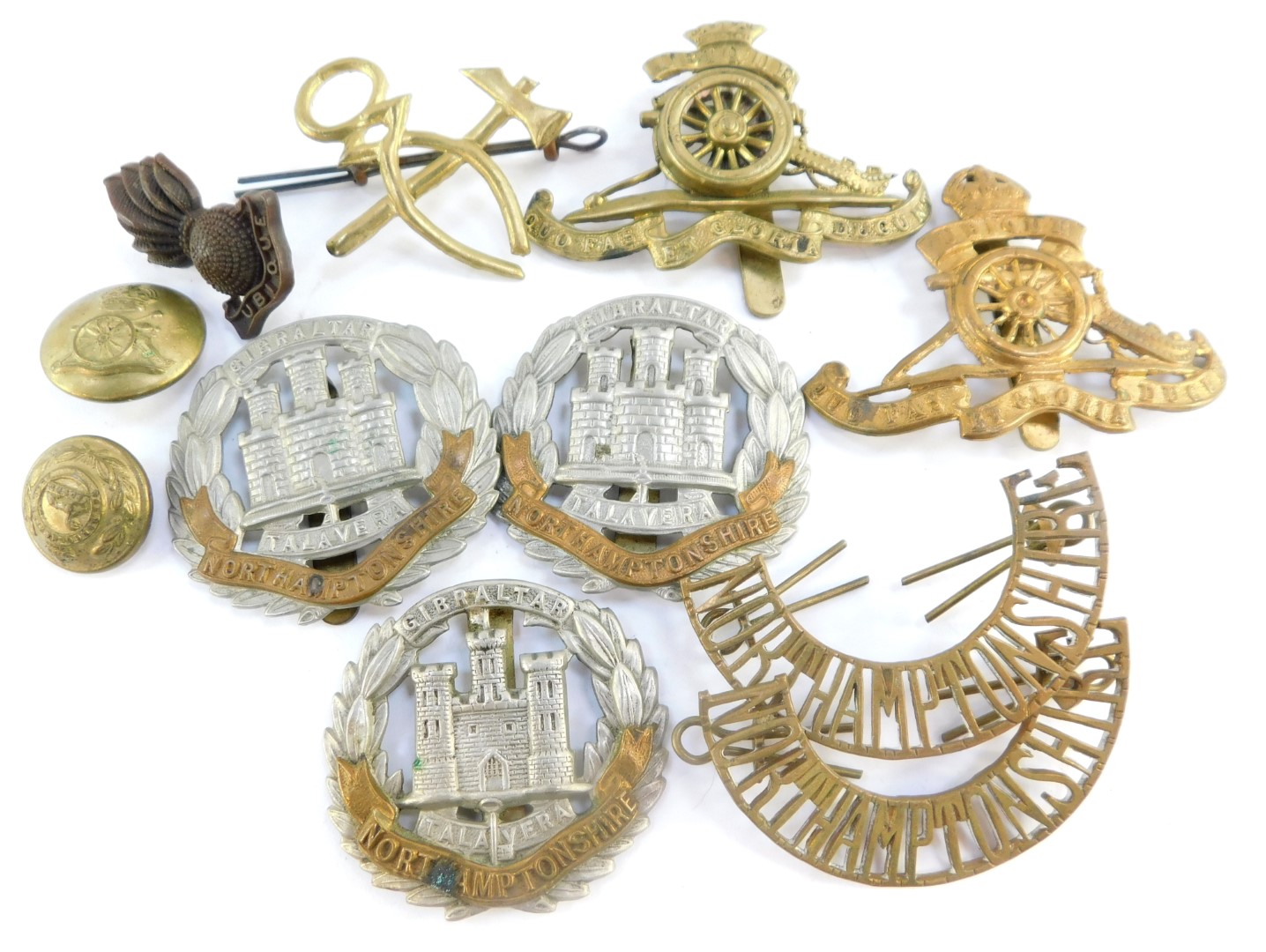 Military cap badges and buttons, including the Northamptonshire Regiment, and Royal Artillery. (a qu