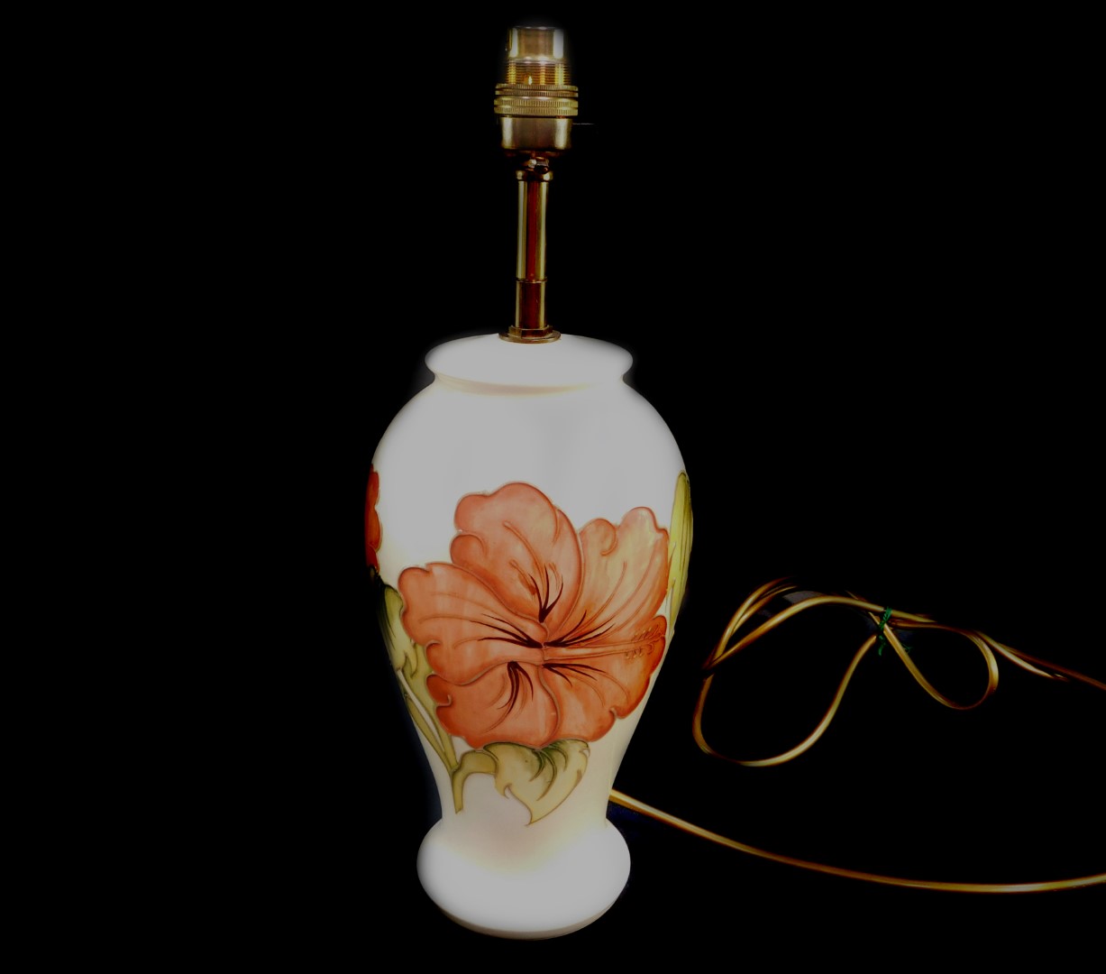 A Moorcroft pottery table lamp decorated in the Hibiscus pattern, of baluster form, decorated agains