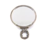 An Edward VII silver backed hand mirror, of circular form, with leaf scroll handle, inset bevelled g