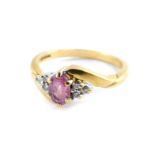 An 18ct gold pink sapphire and diamond set ring, in a crossover design, size O., 3.4g.