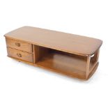 An Ercol dark elm Minerva 844 two drawer coffee table, raised on castors, 40cm high, 25cm wide, 52cm