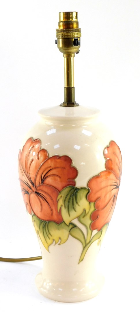 A Moorcroft pottery table lamp decorated in the Hibiscus pattern, of baluster form, decorated agains