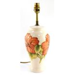 A Moorcroft pottery table lamp decorated in the Hibiscus pattern, of baluster form, decorated agains