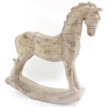 A carved wooden figure of a rocking horse, artificially aged, 55cm high, 50cm wide.