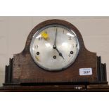 An early 20thC oak Napolean hat mantel clock with three winding holes, Arabic numerals, eight day