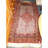 A Keshan wool rug, beige ground with central medallion, and floral red and blue borders, 186cm x