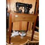 A Singer 306K sewing machine, with accessories, enclosed within a mahogany table, 96cm high.