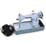 A Jones blue electric sewing machine, with foot pedal.