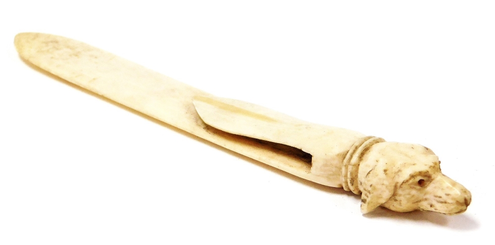 An early 19thC ivory clip or bookmark, of arrow form with dog head knop, 12cm high.