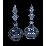 A pair of early 19thC balloon glass decanters, each with elaborate finial stopper, the bodies with e