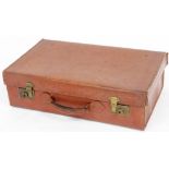 An vintage leather suitcase, with brass clip buckles and carrying handles, with a canvas lined inter