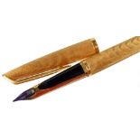 A Waterman's fountain pen, in engine turned gilt, with shaped clip and enclosed 18K nib, 13.5cm long
