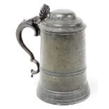 A 19thC pewter tankard by Watts and Hart, with anthemion thumb piece, scroll handle with a glass bot