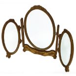 An Edwardian gilt wood and plaster triple dressing table mirror, with oval bezel plates and moulded