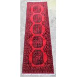 A Persian wool pile runner, on red ground with central five medallion separation, on a black border,