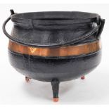 A 19thC cast iron cauldron, with copper bands, 26cm high, 29cm diameter.