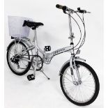 A Urbanisi Viking folding bicycle, with a white basket.