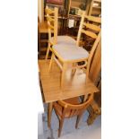 A teak kitchen table and three associated chairs.