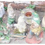 A group of painted garden ornaments, to include three gnomes and a boot planter. (4)