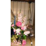 A cast metal altar flower stand, with floral artificial flower display of various pink flowers on a