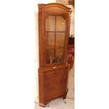 A walnut corner cabinet, with shaped cornice, above six sectional astragal glazed door, with cupboar