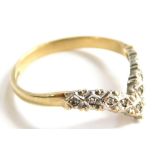 A 9ct gold wishbone ring, illusion set with tiny diamonds, in a white metal setting, on a yellow met