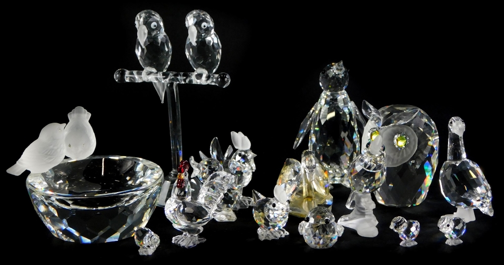 A collection of Swarovski Crystal birds, to include a penguin, two parrots on a perch, an owl, goose