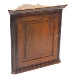 A 19thC oak corner cabinet, with a moulded cornice, with a single panelled door, 74cm high, 74 wide.