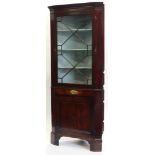 An early 19thC mahogany standing corner cabinet, with a moulded cornice above an astragal glazed doo