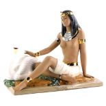A Nadal ceramic figure of a seated nude Cleopatra, beside a swan on a rectangular base, 40cm long.