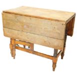 A 19thC scrub top pine gateleg kitchen table, with drop leaf.