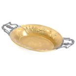 A continental Art Nouveau brass and pewter two handled dish, embossed and cast with lilies and tulip