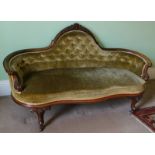 A Victorian walnut settee, with arched and carved top rail above a button upholstered back, with ser