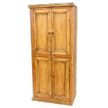 A pine cupboard, with a moulded cornice above two pairs of panelled doors, on a plinth, lacking back