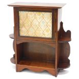 An Edwardian mahogany small cupboard, with a moulded cornice, above a glazed door, inset with embroi