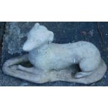 A composition recumbent greyhound garden ornament, 57cm long.