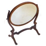 An Edwardian, mahogany and boxwood strung table mirror, the oval glass flanked by s scroll supports