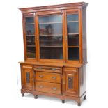 A late 19th/early 20thC walnut bookcase, the top with a moulded cornice with three glazed doors encl