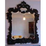 A 19thC carved rococo wall mirror, with c and s shaped scrolls, around a bevelled plate, 135cm high,