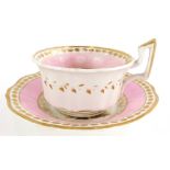 A Rockingham pink ground cup and saucer, decorated with figures, c1825.