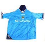 A Manchester City football shirt, size 46/48, signed by some of the team.