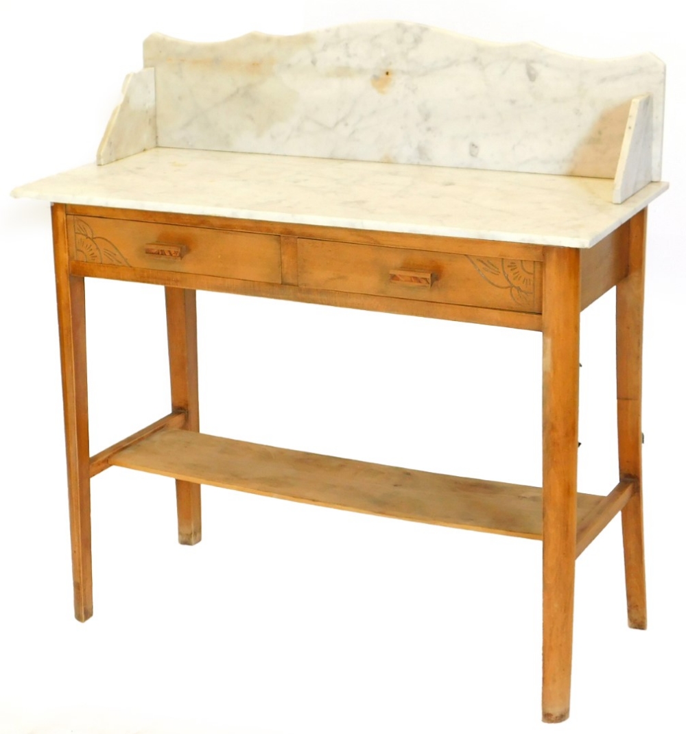 An Art Deco beech washstand, with a white marble top, with two frieze drawers on tapering legs with