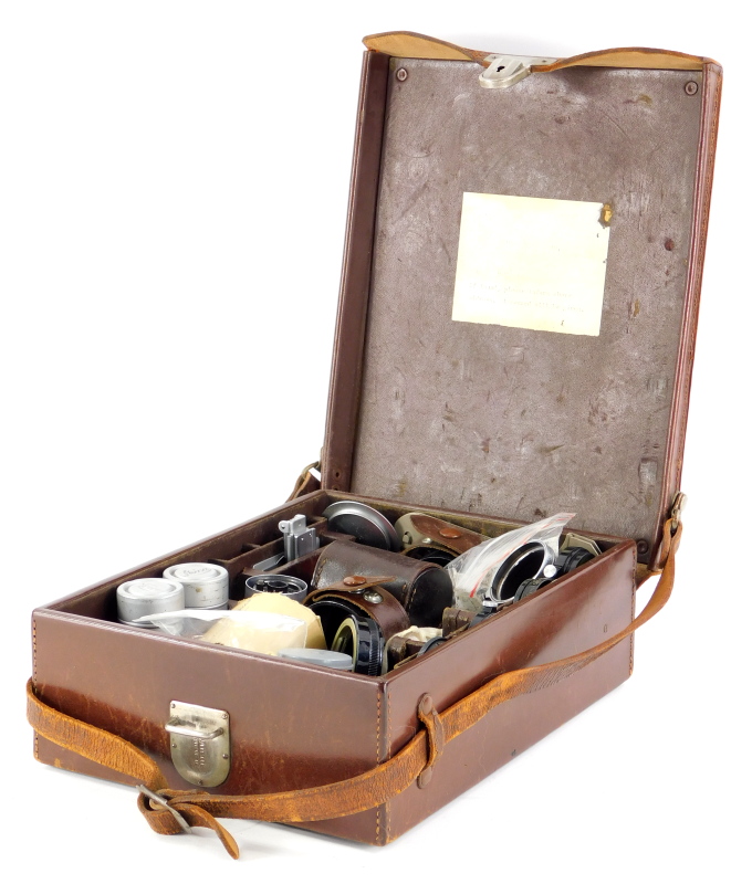 A brown leather Leitz Leica case, containing mixed Leica accessories.