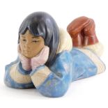 A Nao porcelain figure of an Eskimo child, lying on her front, 19cm long.