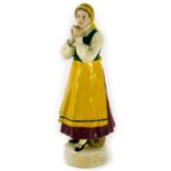 A German Schwarzburger werkstatten figure of a peasant lady, wearing a yellow pinafore and brown dre